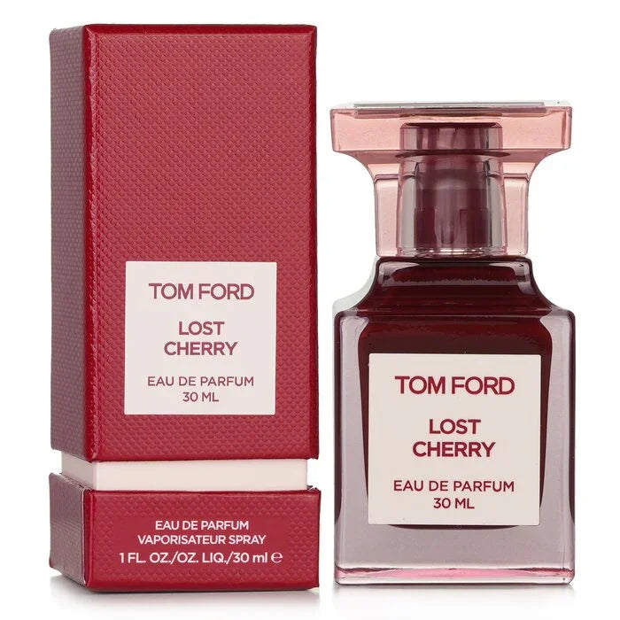 A 30ml Tom Ford Lost Cherry Eau De Parfum bottle with translucent pink glass and deep red liquid, standing next to its matching burgundy-red textured box with a white-and-burgundy logo label.
