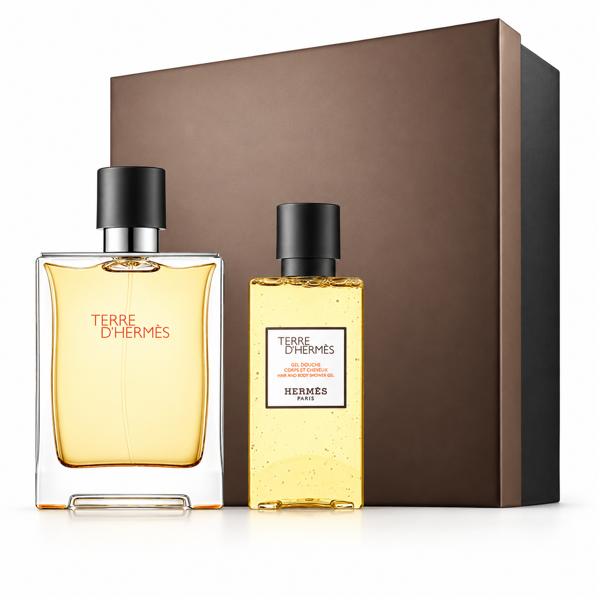 Hermès Terre d’Hermès luxury fragrance gift set for men, featuring an elegant amber-colored perfume bottle with a black cap and matching hair and body shower gel. Presented alongside a sophisticated brown gift box against a clean white background. A premium masculine fragrance gift set, perfect for gifting and special occasions.